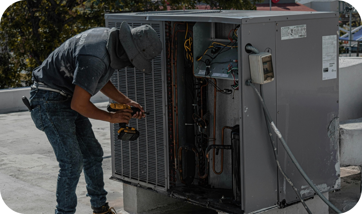 A man repairing an AC unit, a weatherization improvement