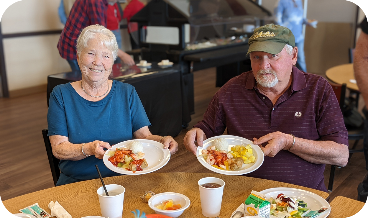 A man and woman eating together in a cafeteria