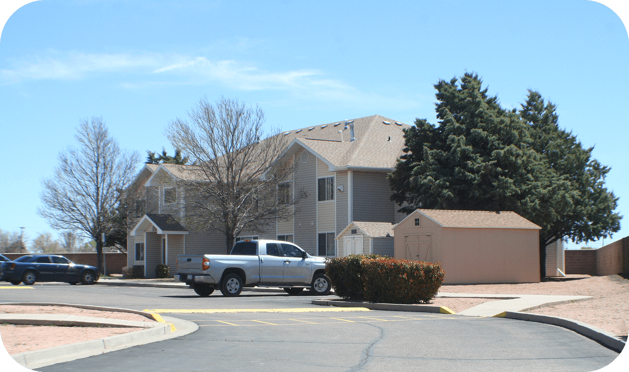 Exterior of a duplex of apartment homes with pine trees surrounding the building