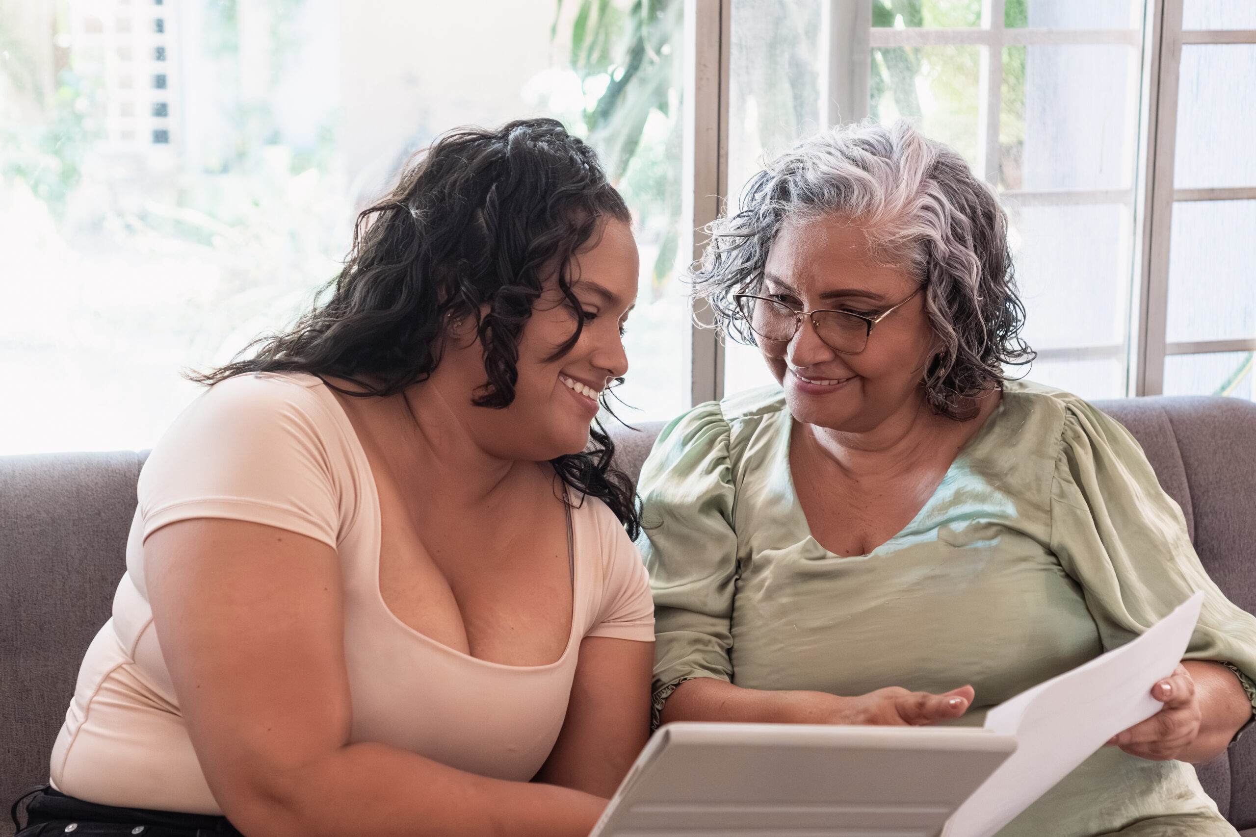 A younger female caregiver reviewing paperwork with an elderly woman