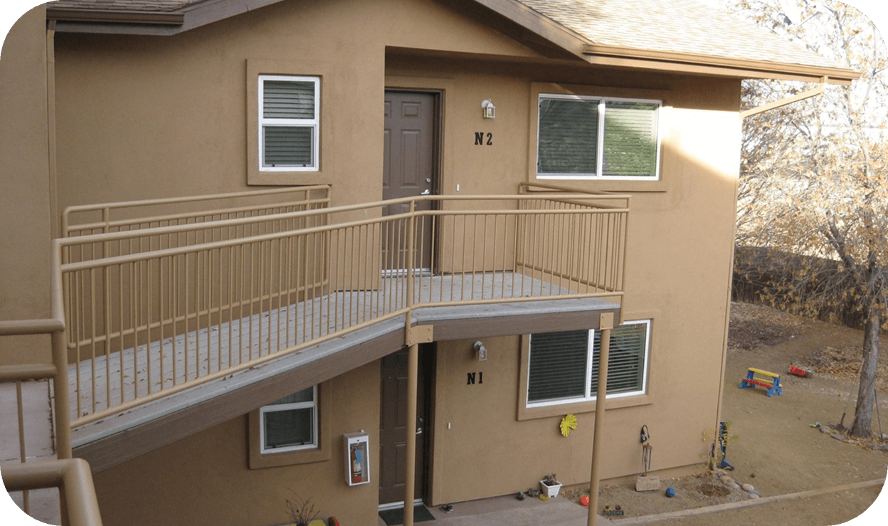 Exterior of apartment a two-story building with kid's toys out front on the first floor