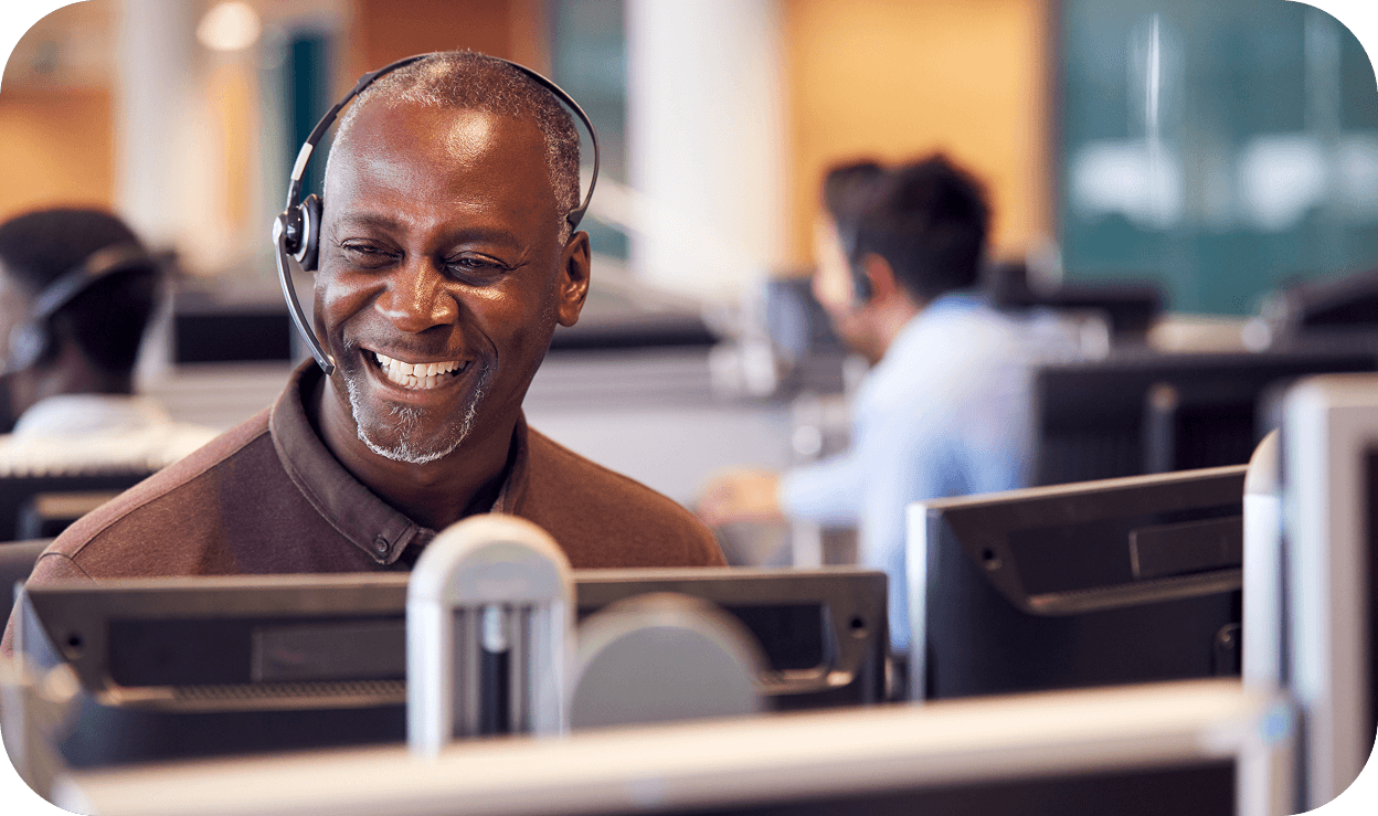 A male call center support caller seeming happy on a call