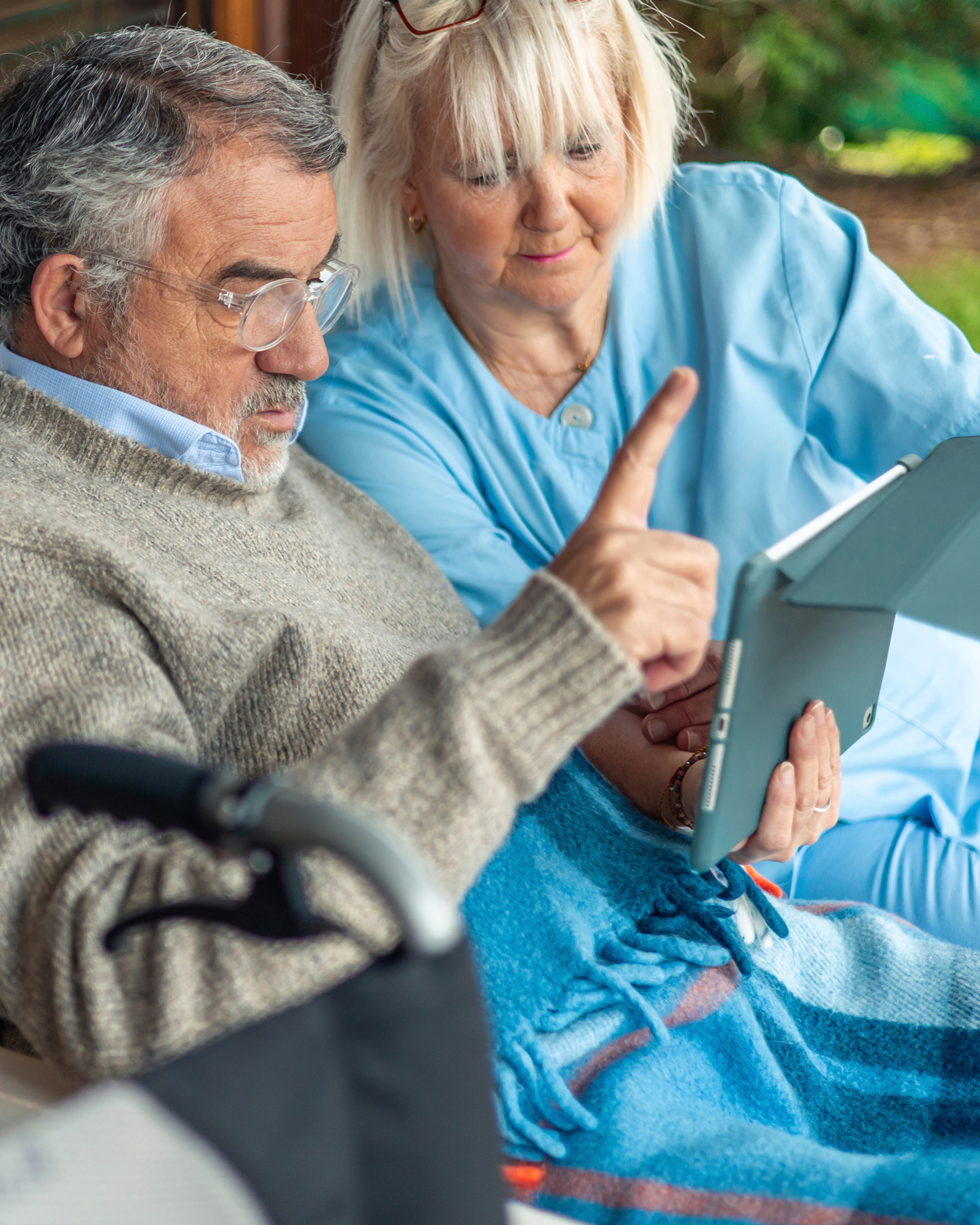 An elderly man and woman viewing a tablet together
