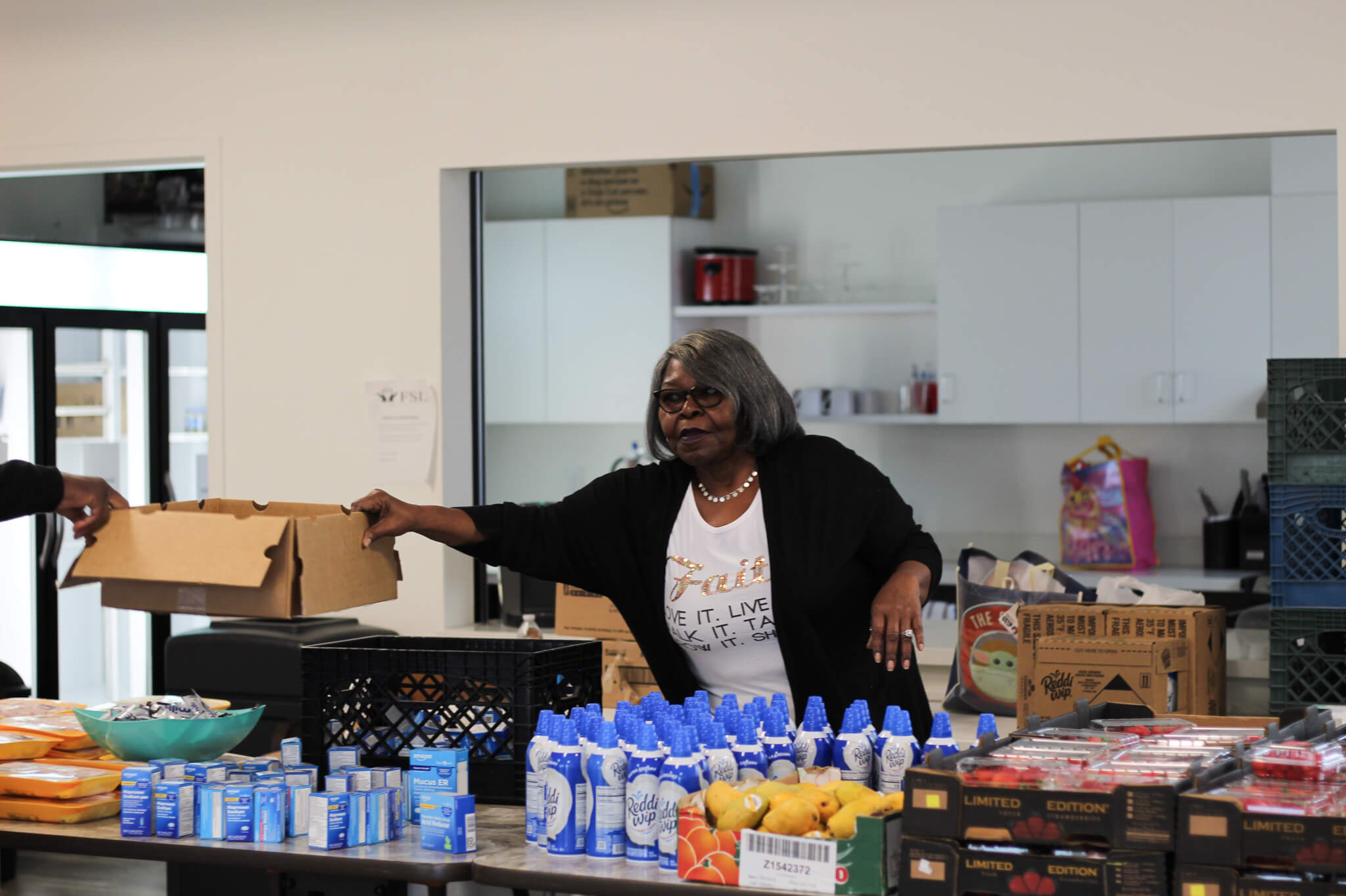 Action shot of volunteer, Joyce, assisting with packing lunches