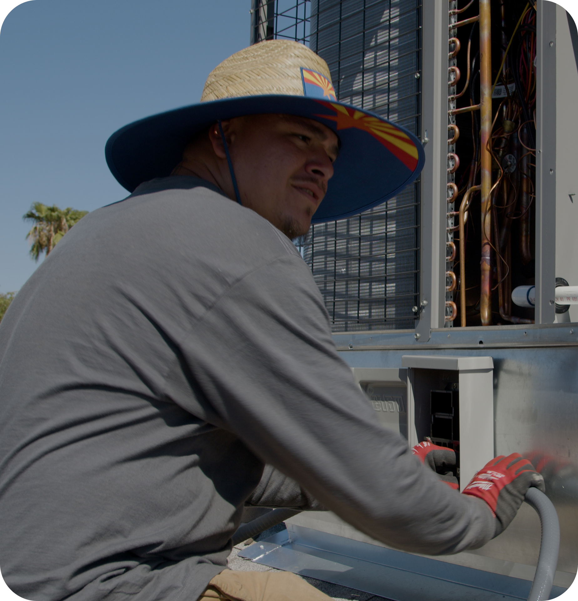 A man installing an AC unit on a roof